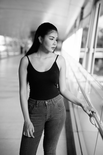 Retrato de joven bella mujer asiática explorando la ciudad en blanco y negro