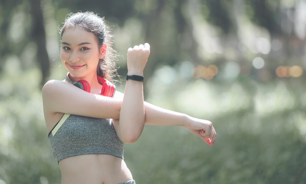 Retrato de joven y bella mujer asiática haciendo ejercicio en el parque. Modelo de fitness femenino caucásico trabajando en la mañana.