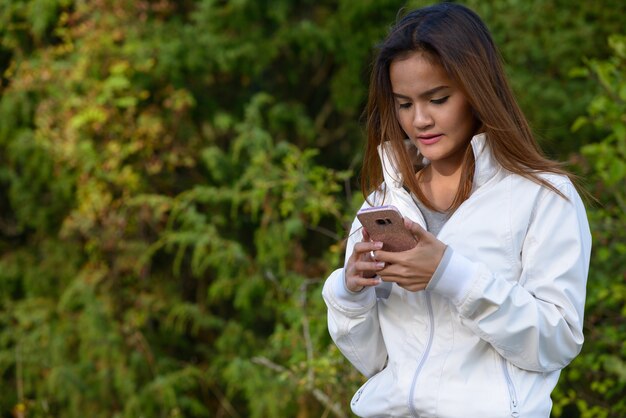 Retrato de joven bella mujer asiática relajándose en la naturaleza al aire libre