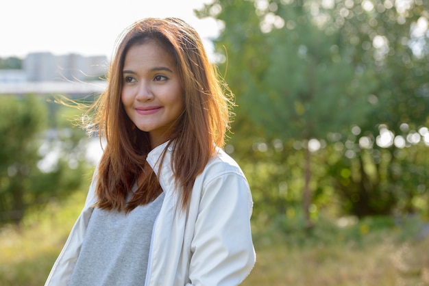 Retrato de joven bella mujer asiática relajándose en la naturaleza al aire libre