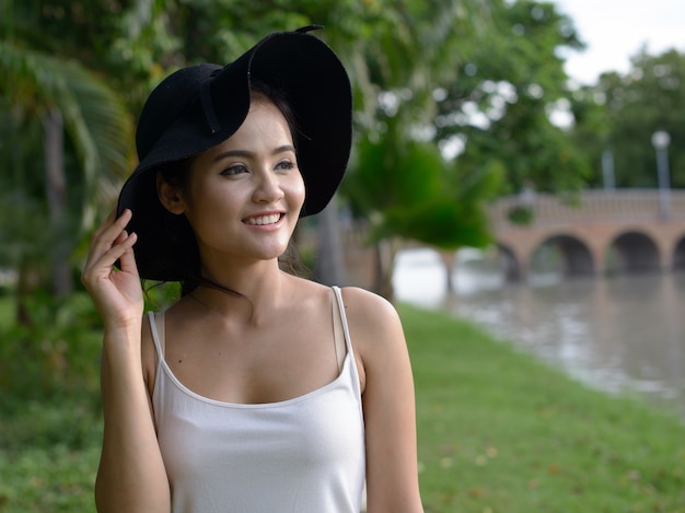 Retrato de joven bella mujer asiática relajante en el parque al aire libre