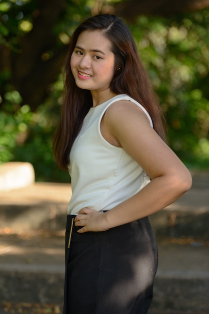 Retrato de joven bella mujer asiática relajante en el parque al aire libre