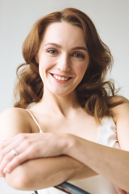 Retrato de joven bella mujer en camisa blanca sobre fondo blanco.