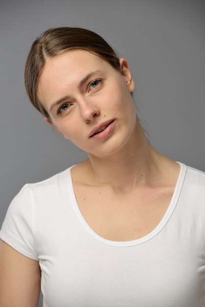 Foto retrato de una joven bella mujer con una camiseta blanca