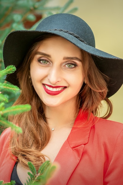 Retrato de una joven y bella mujer caucásica con árbol sonriendo