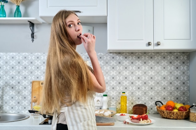 Retrato de una joven y bella mujer cocinando en casa en la cocina, espacio de copia.