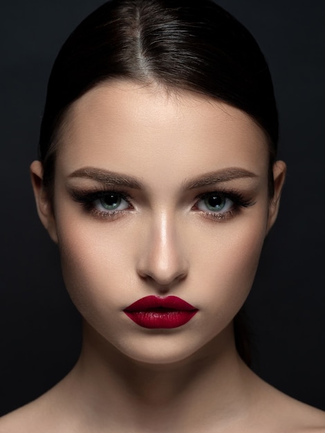 Retrato de joven bella mujer con maquillaje de noche. Lápiz labial rojo mate. Concepto de maquillaje clásico. Belleza de la moda