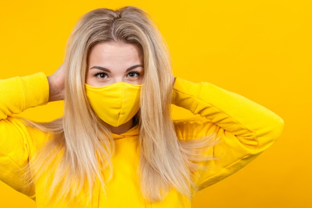 Retrato de joven bella mujer en máscara protectora amarilla