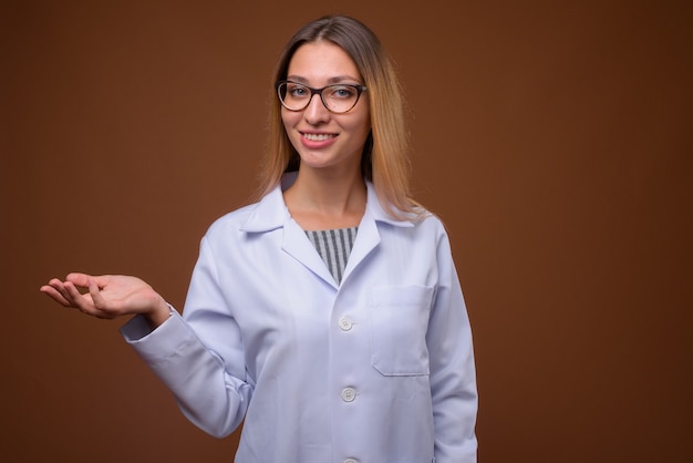 Retrato de joven bella mujer médico mostrando copyspace