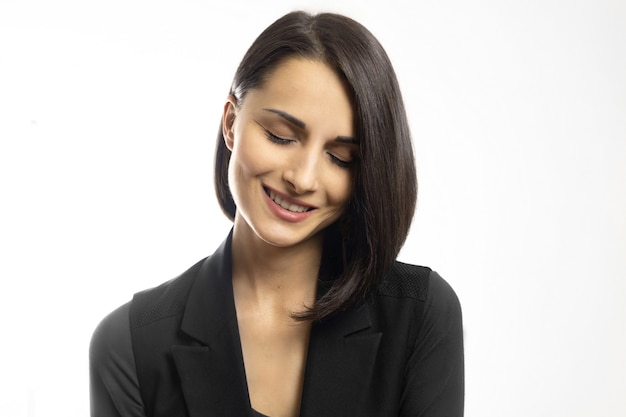 Retrato de joven bella mujer morena sonriente con los ojos cerrados sobre fondo blanco.