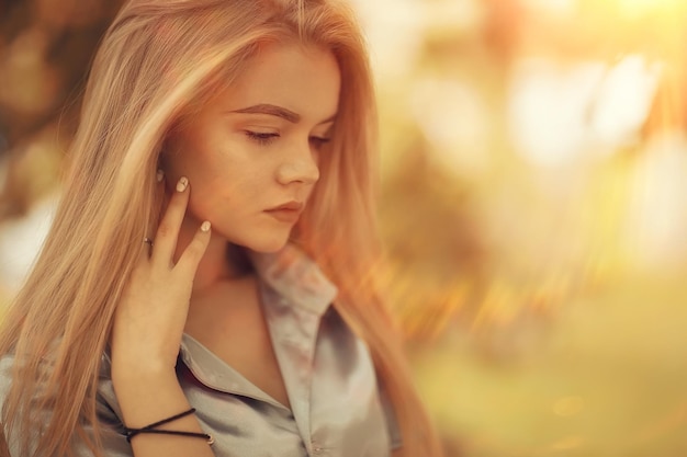 Retrato de una joven y bella mujer rubia con rayos de sol y resplandor