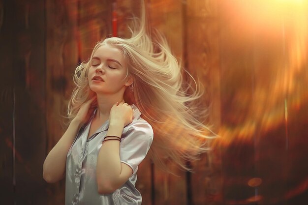 Retrato de una joven y bella mujer rubia con rayos de sol y resplandor