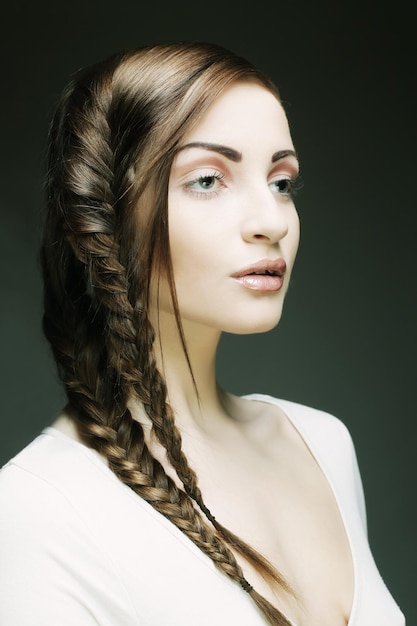 Retrato de joven y bella mujer rubia con trenzas creativas ha