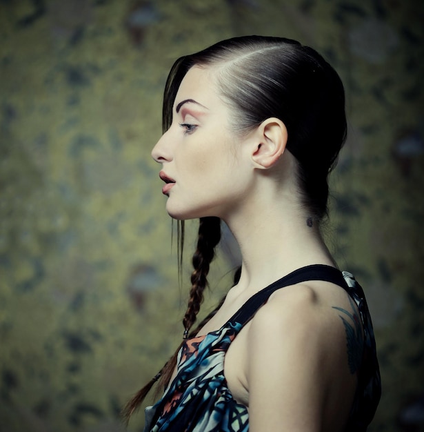 Retrato de joven y bella mujer rubia con trenzas creativas ha