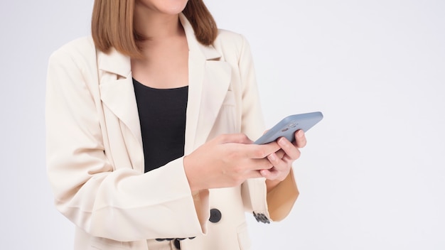 Retrato de joven bella mujer en traje con teléfono inteligente sobre fondo blanco.