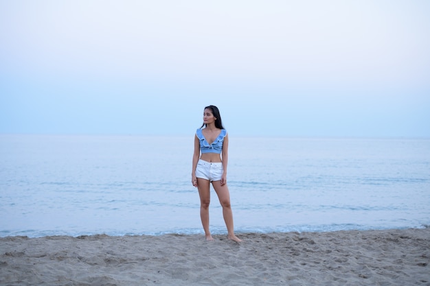 Retrato de joven bella mujer turista asiática relajante en la playa