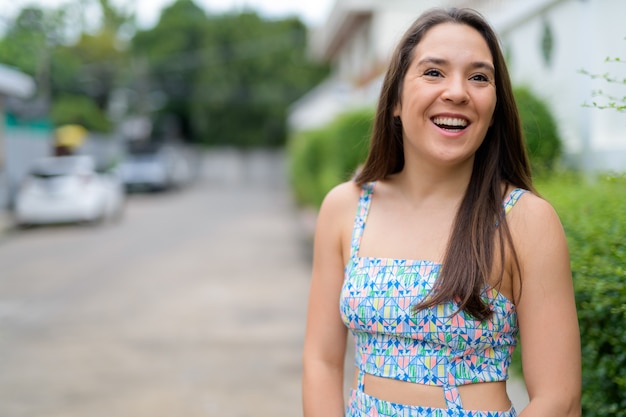 Retrato de joven bella mujer con vestido de verano en la calle