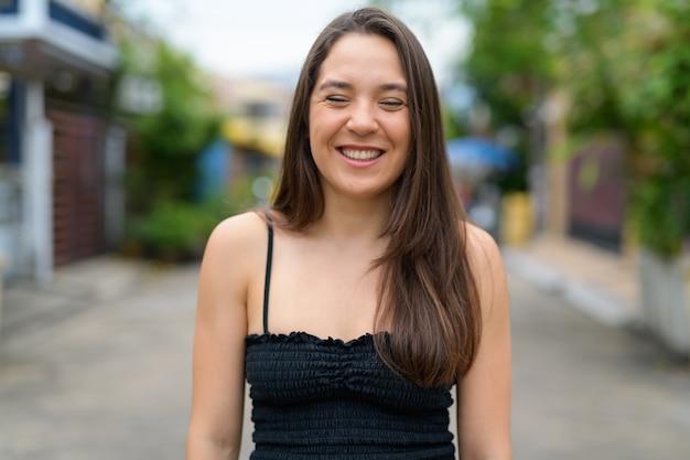 Retrato de joven bella mujer vistiendo camiseta sin mangas en la calle