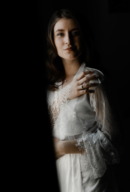 Retrato de una joven y bella novia durante los preparativos de la mañana el día de la boda. hermosa chica tiene un velo en la cabeza. mañana de la boda de la novia.