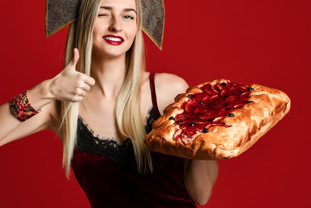 Retrato de una joven y bella rubia sosteniendo un delicioso pastel de cereza casero