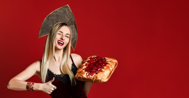 Retrato de una joven y bella rubia sosteniendo un delicioso pastel de cereza casero