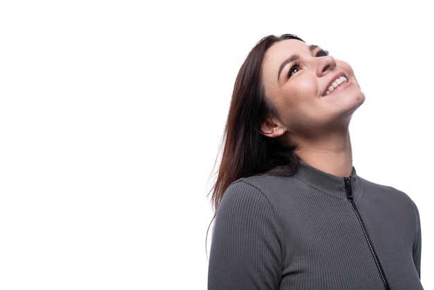 Retrato de una joven bruneta alegre y alegre en un fondo blanco de estudio