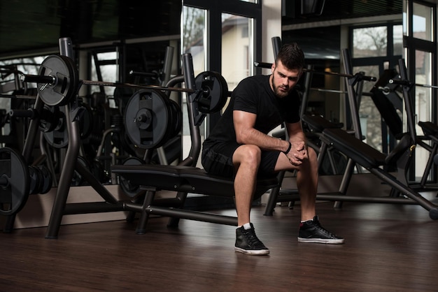 Foto retrato de un joven en buena forma física descansando en un club moderno de salud