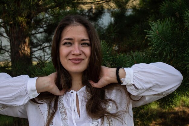 Foto retrato de una joven de cabello marrón hermosa con ojos verdes y una blusa blanca