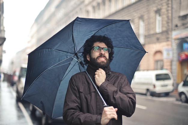 retrato de un joven en la calle bajo la lluvia