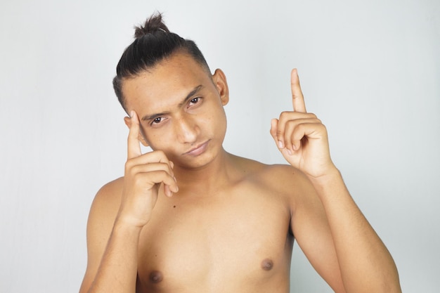 Foto retrato de un joven sin camisa contra un fondo blanco