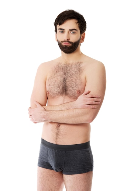 Foto retrato de un joven sin camisa de pie contra un fondo blanco