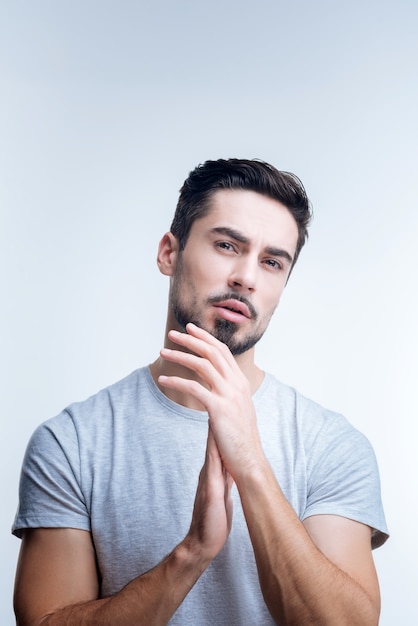 retrato, de, un, joven, en, camiseta gris, posar, contra, un, pared blanca