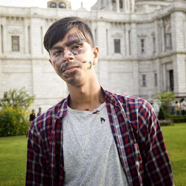 Foto retrato de un joven con la cara desordenada de pie contra el edificio