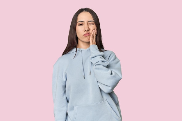 Retrato de una joven caucásica moderna en el fondo del estudio con un fuerte dolor de dientes dolor molar