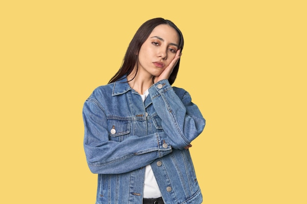 Foto retrato de una joven caucásica moderna en el fondo del estudio que está aburrida y fatigada