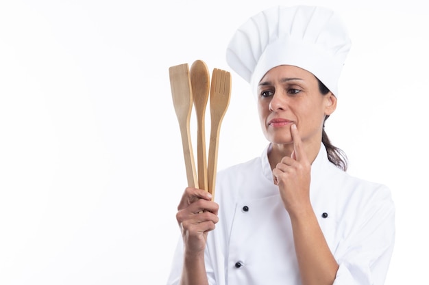 Retrato de una joven chef caucásica pensando qué plato hará ahora sobre fondo blanco con espacio para copiar