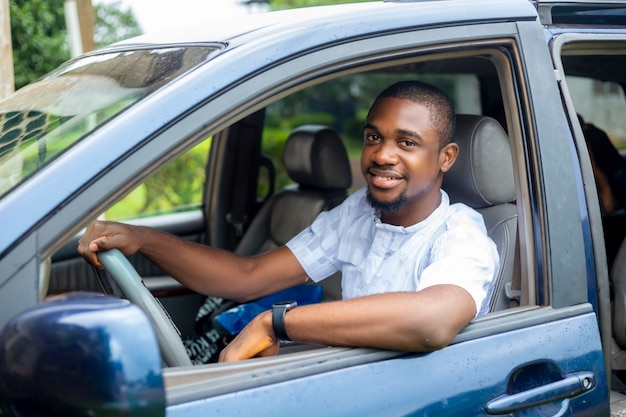 Retrato de un joven conductor guapo africano negro en taxi coche