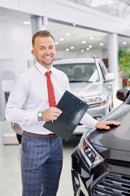 Foto retrato de joven consultor de showroom de coches