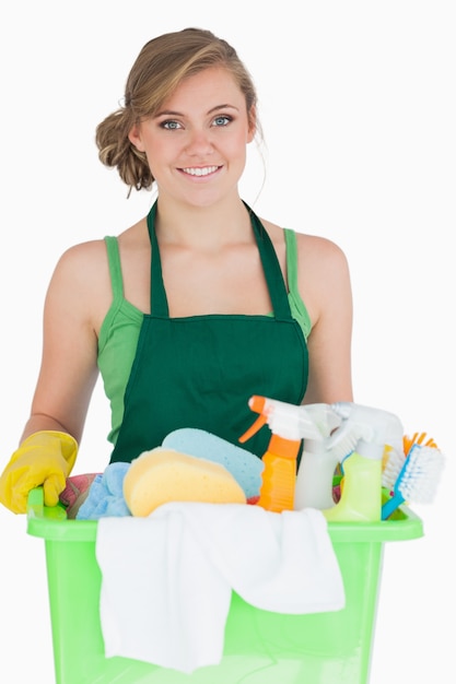 Retrato de joven criada llevando suministros de limpieza