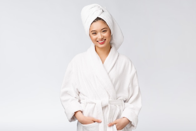 Retrato de una joven dama asiática feliz en bata de baño.