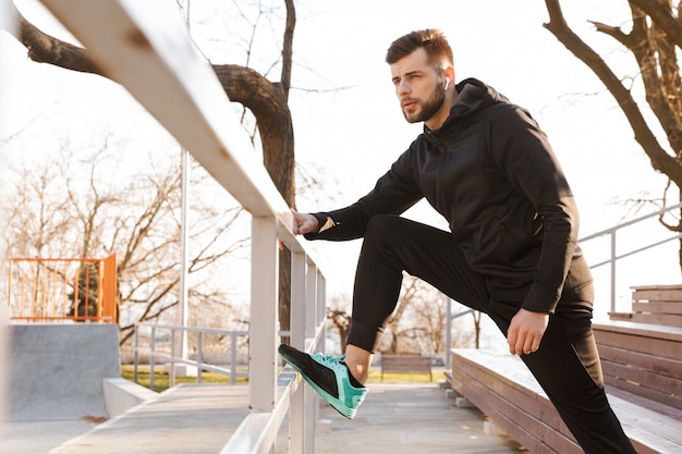 Retrato de joven deportista confiado en auriculares