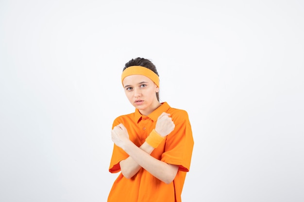 Retrato de joven deportista en traje naranja listo para pelear.