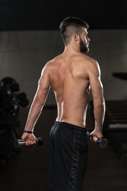 retrato, de, un, joven, deportivo, hombre, en, el, moderno, gimnasio, con, equipo de ejercicio