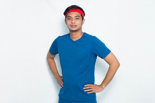 Retrato joven deportivo vestido con camiseta azul sobre fondo blanco.