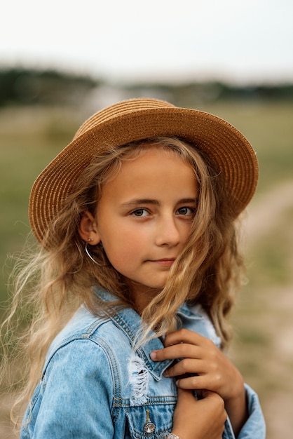 Retrato de una joven descansando en el verano y caminando en el campo con un sombrero