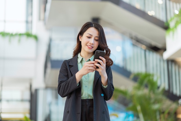 Retrato de una joven directora asiática sosteniendo un teléfono