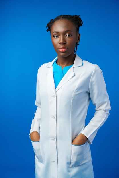 Retrato de una joven doctora africana en un estudio azul