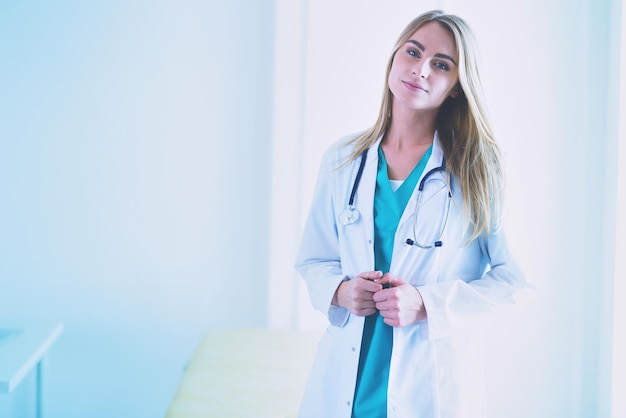 Retrato de una joven doctora con aipads en la mano en un consultorio médico