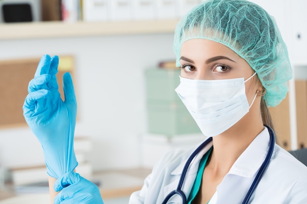 Retrato de joven doctora con máscara y guantes