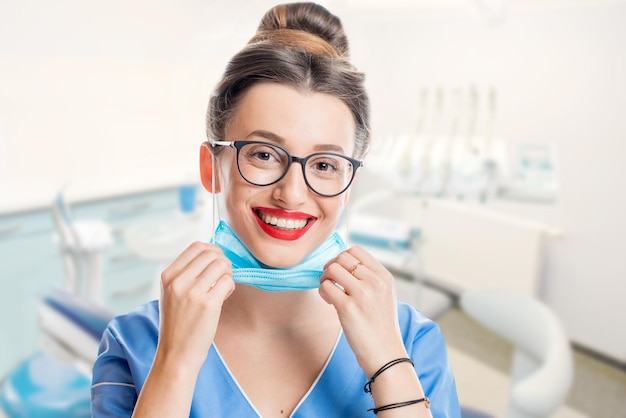 Retrato de una joven doctora con mascarilla en el consultorio dental